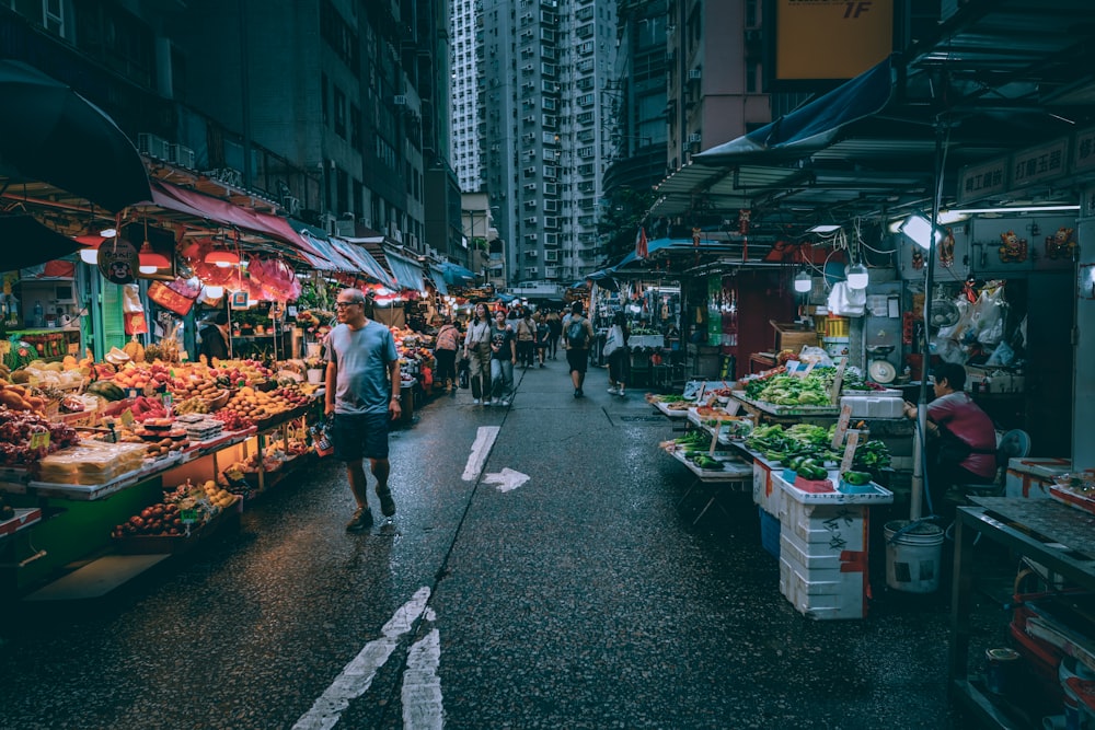 a man walking down a street next to a market