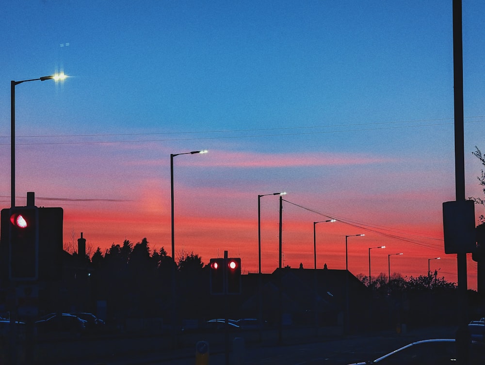 a red traffic light sitting next to a street filled with traffic