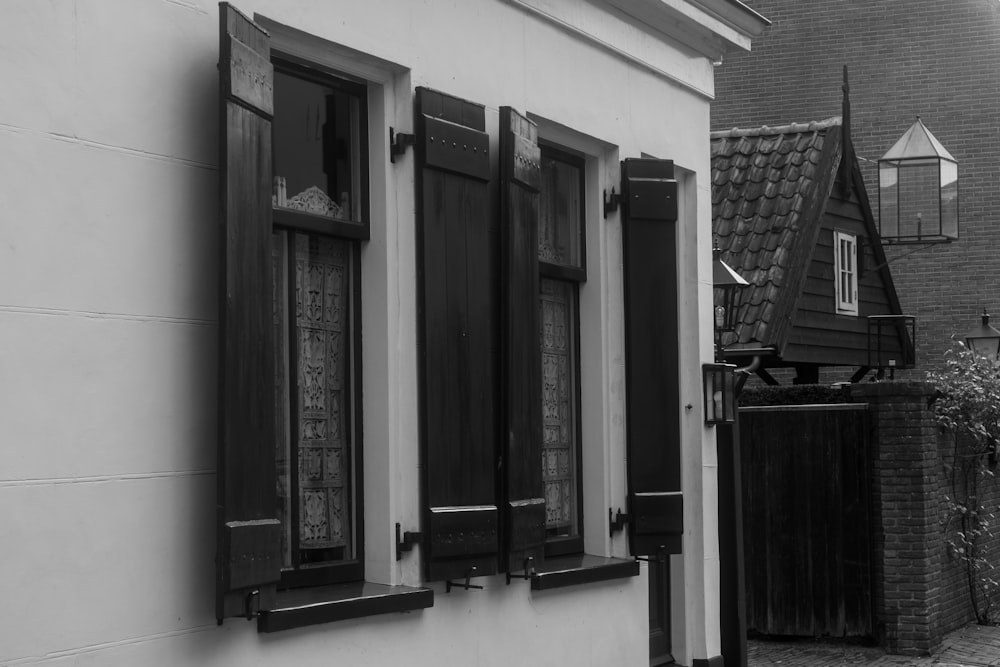 a black and white photo of a house with shutters