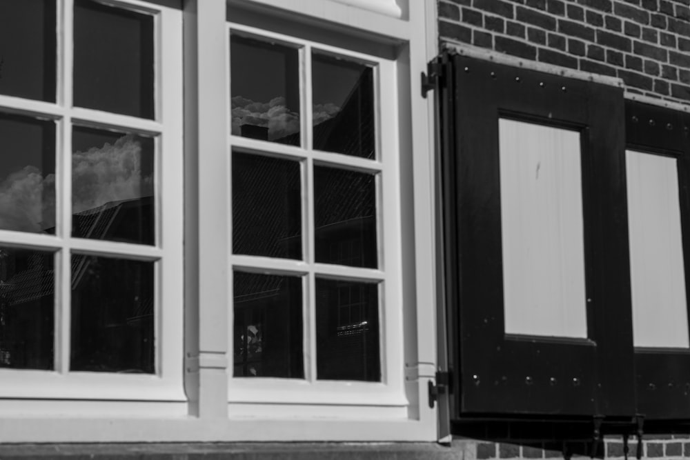 a black and white photo of a window and a brick building