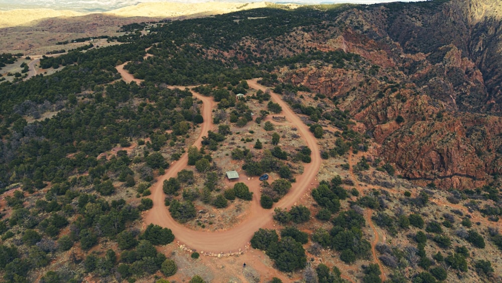 an aerial view of a dirt road surrounded by trees