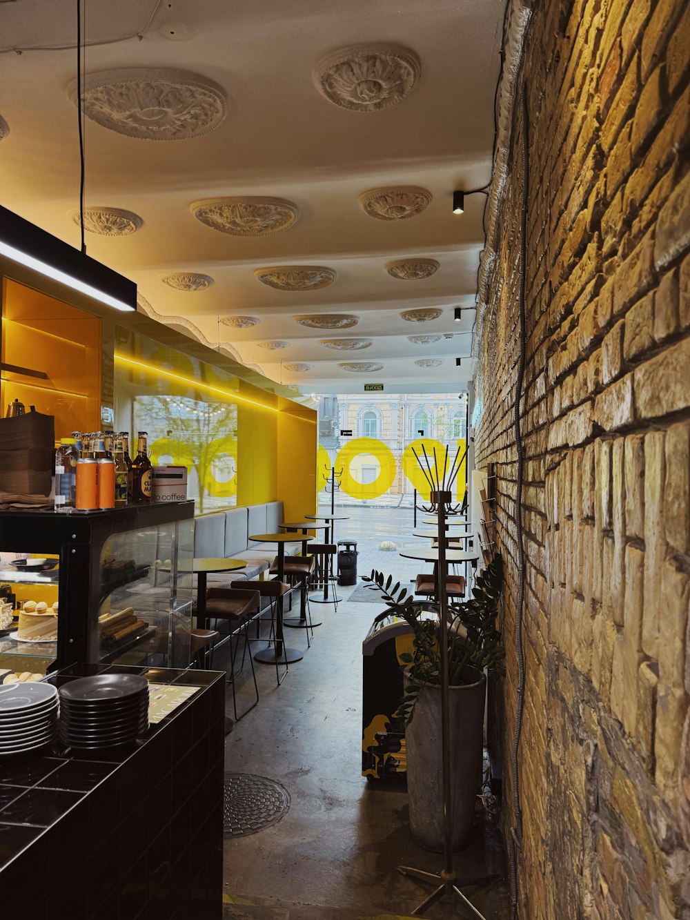 a restaurant with a brick wall and yellow accents