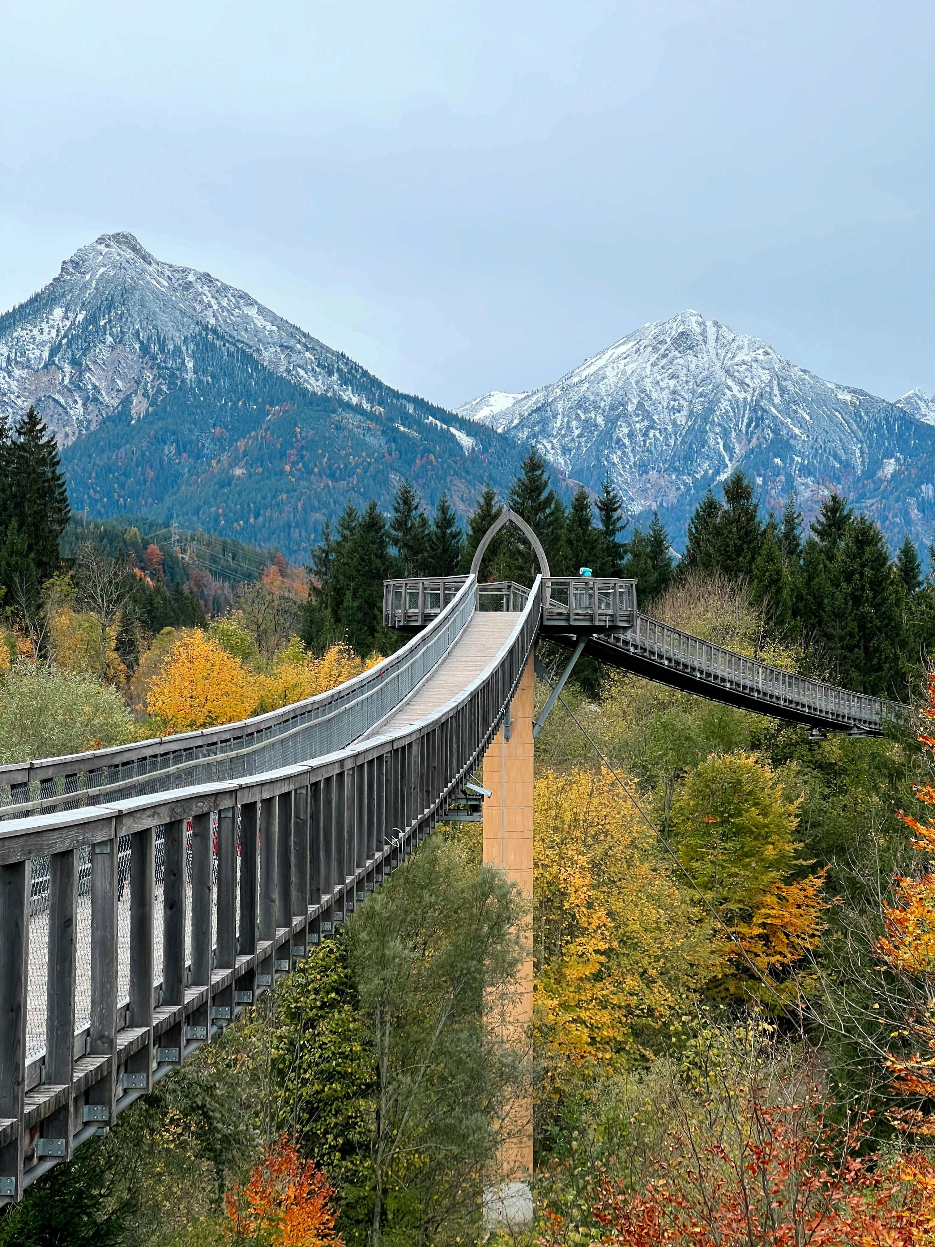 eine Brücke über einen Fluss mit Bergen im Hintergrund