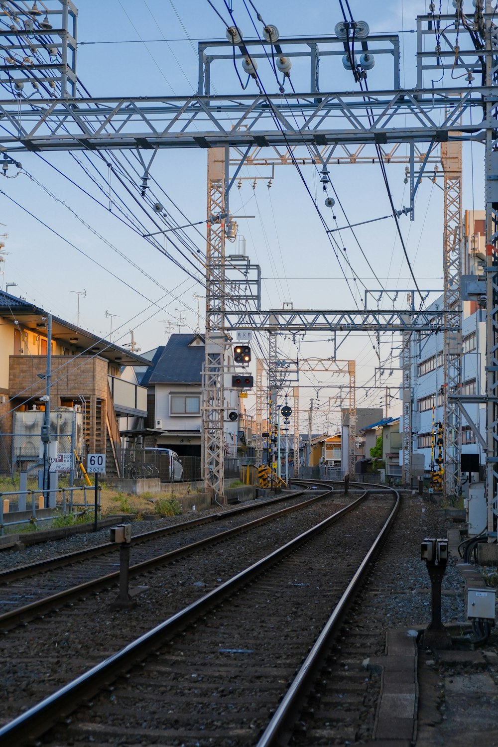 a train track with many electrical wires above it