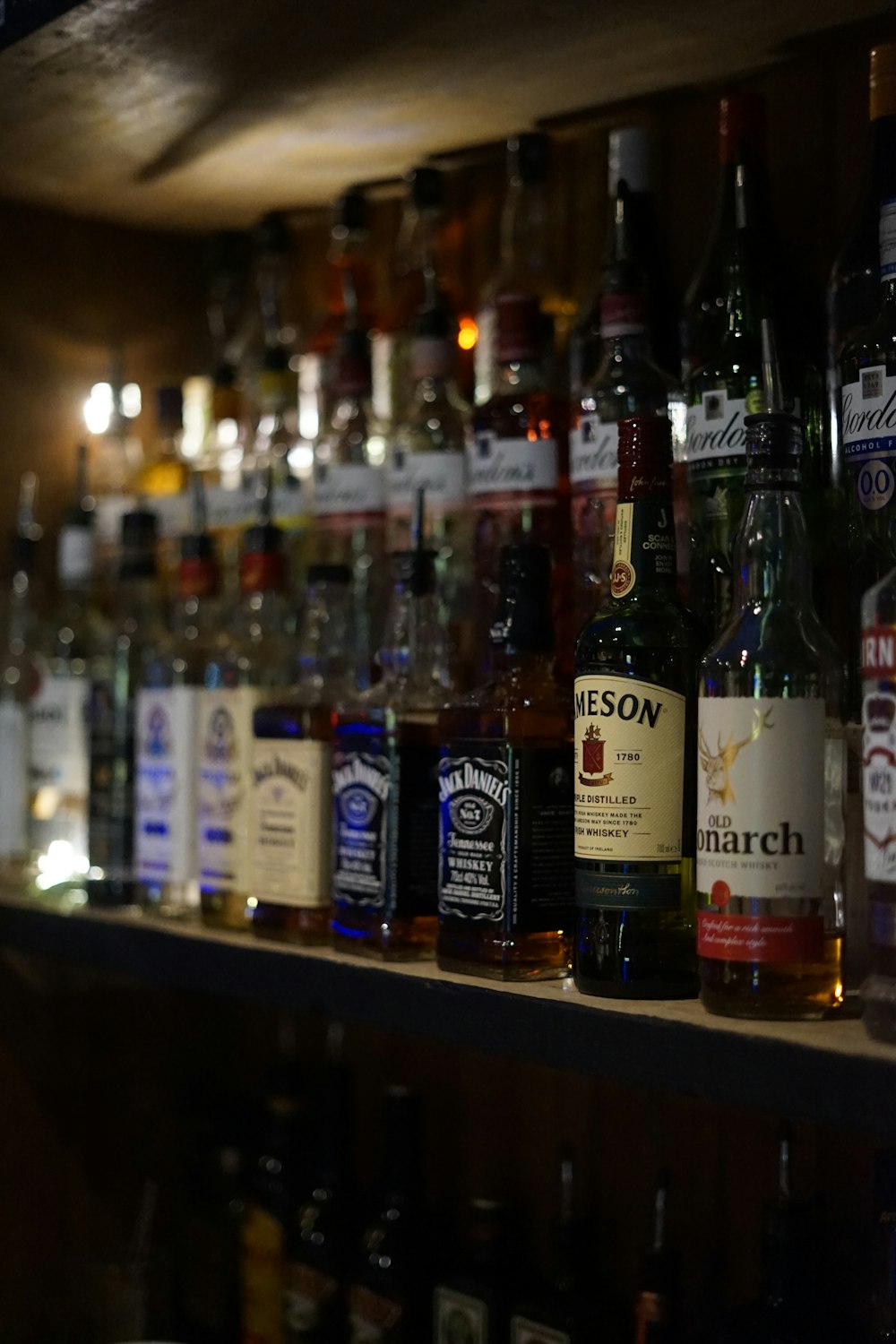 a shelf filled with lots of bottles of alcohol