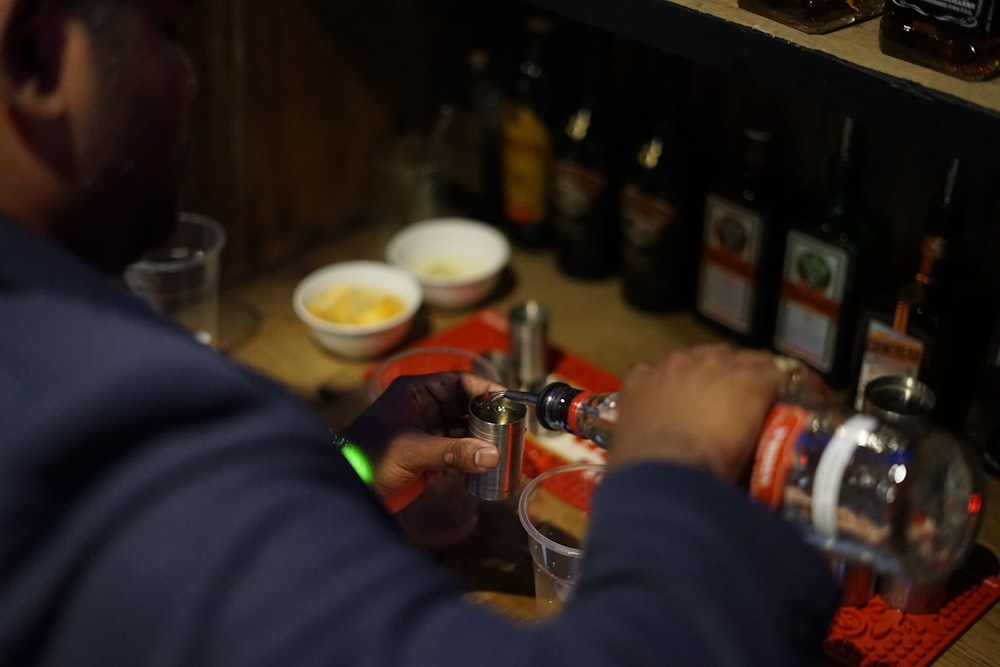 a man pouring a drink into a glass