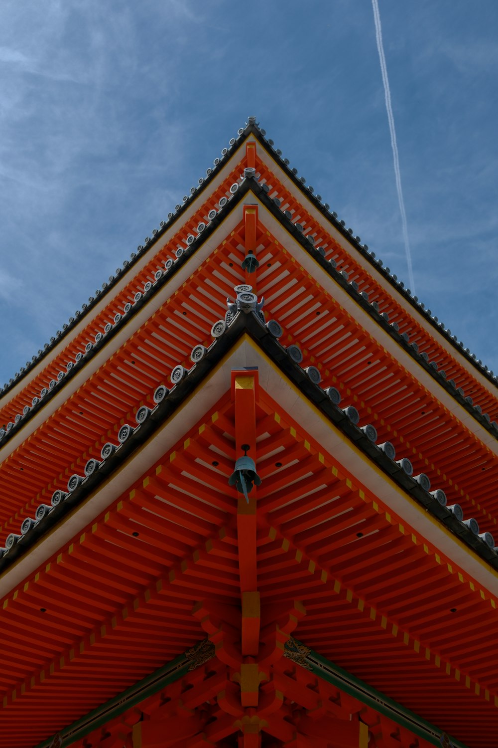 a red and white building with a jet in the sky