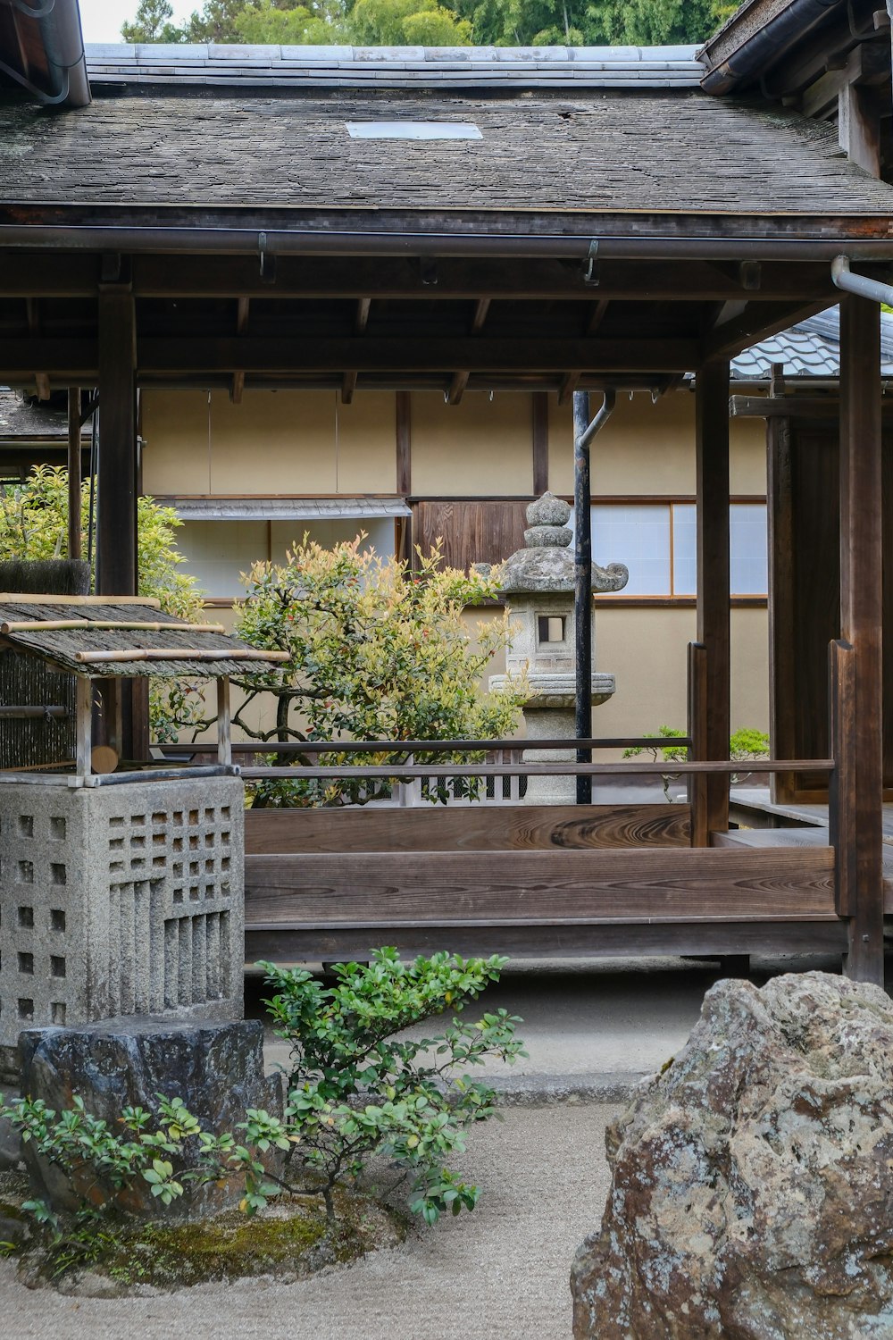 a building with a wooden porch and a stone lantern