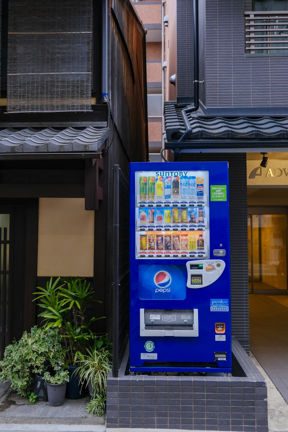 a blue vending machine in front of a building