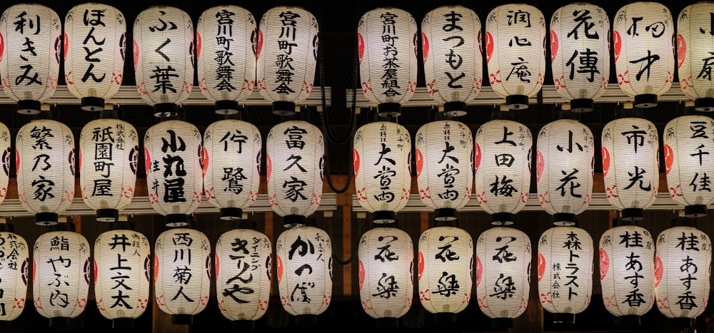 Un tas de lanternes blanches et rouges avec une écriture asiatique dessus