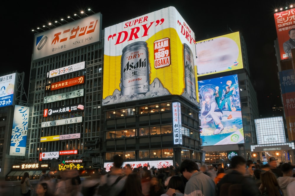 a crowd of people walking around a city at night