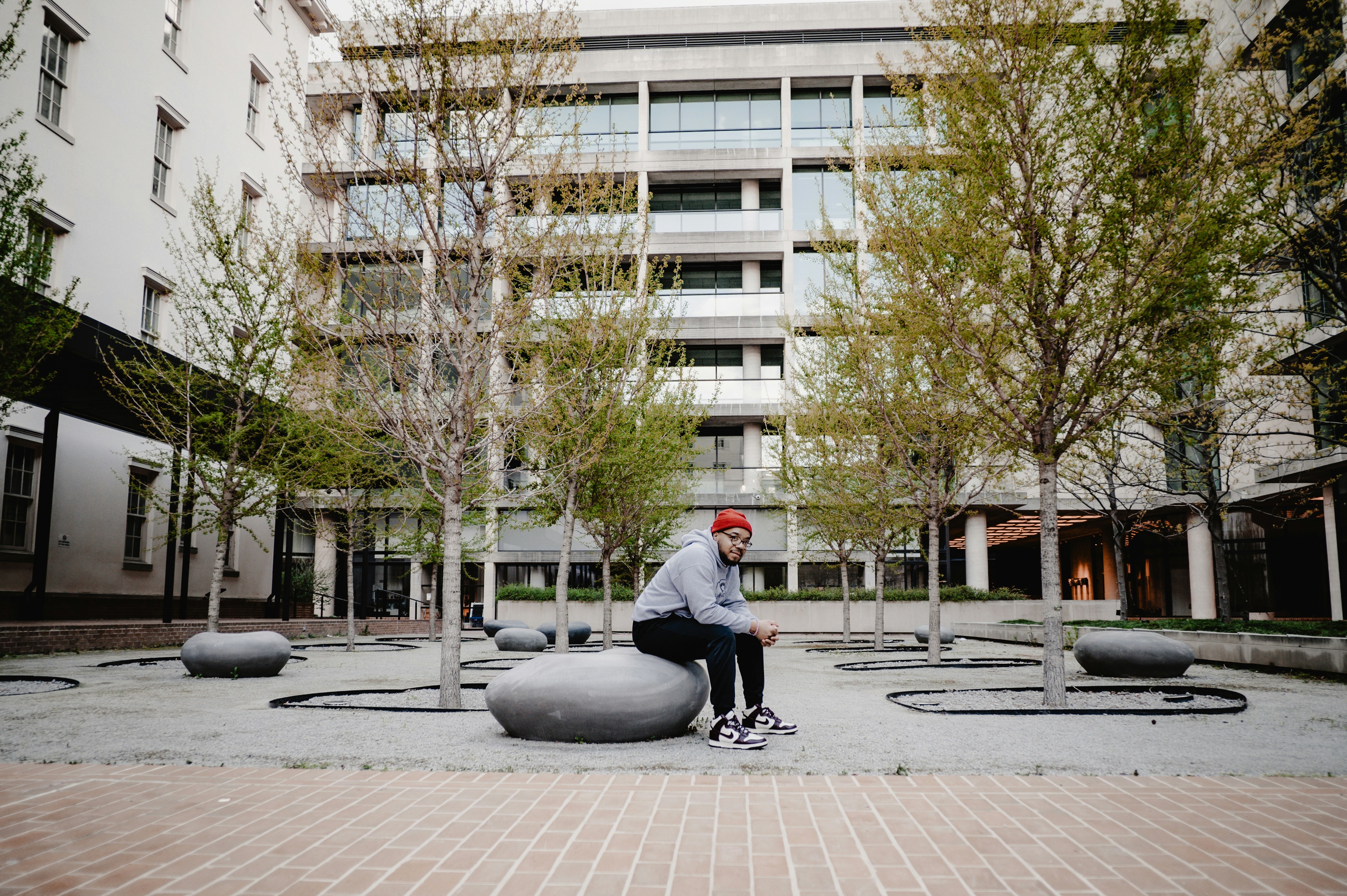 a man sitting on a rock in a courtyard