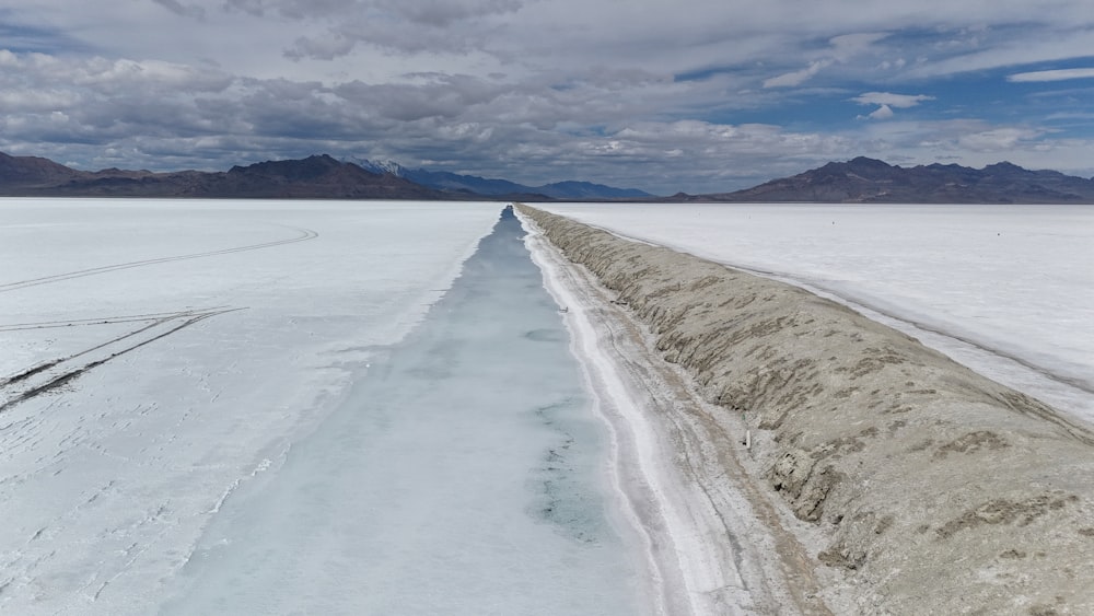 a wide expanse of snow with mountains in the background