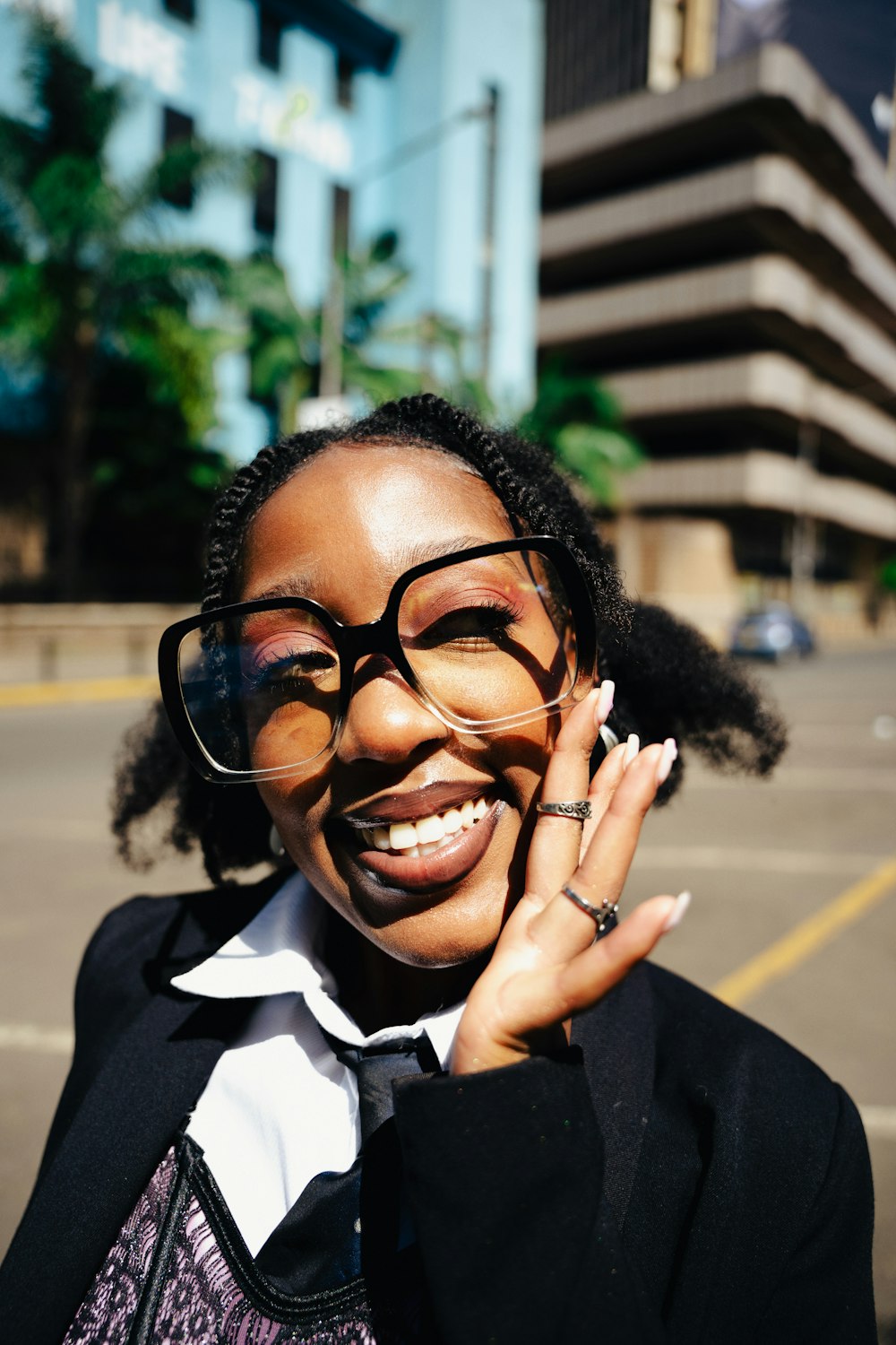 a woman in a suit and tie holding her hand up to her face