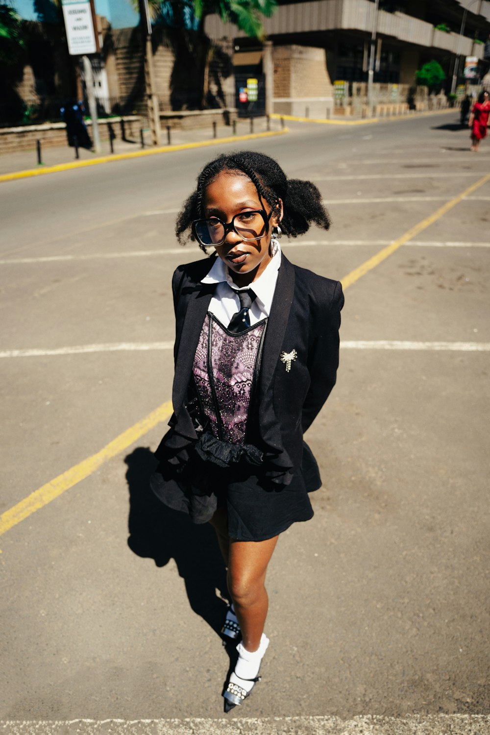 a woman in a suit and tie walking down a street