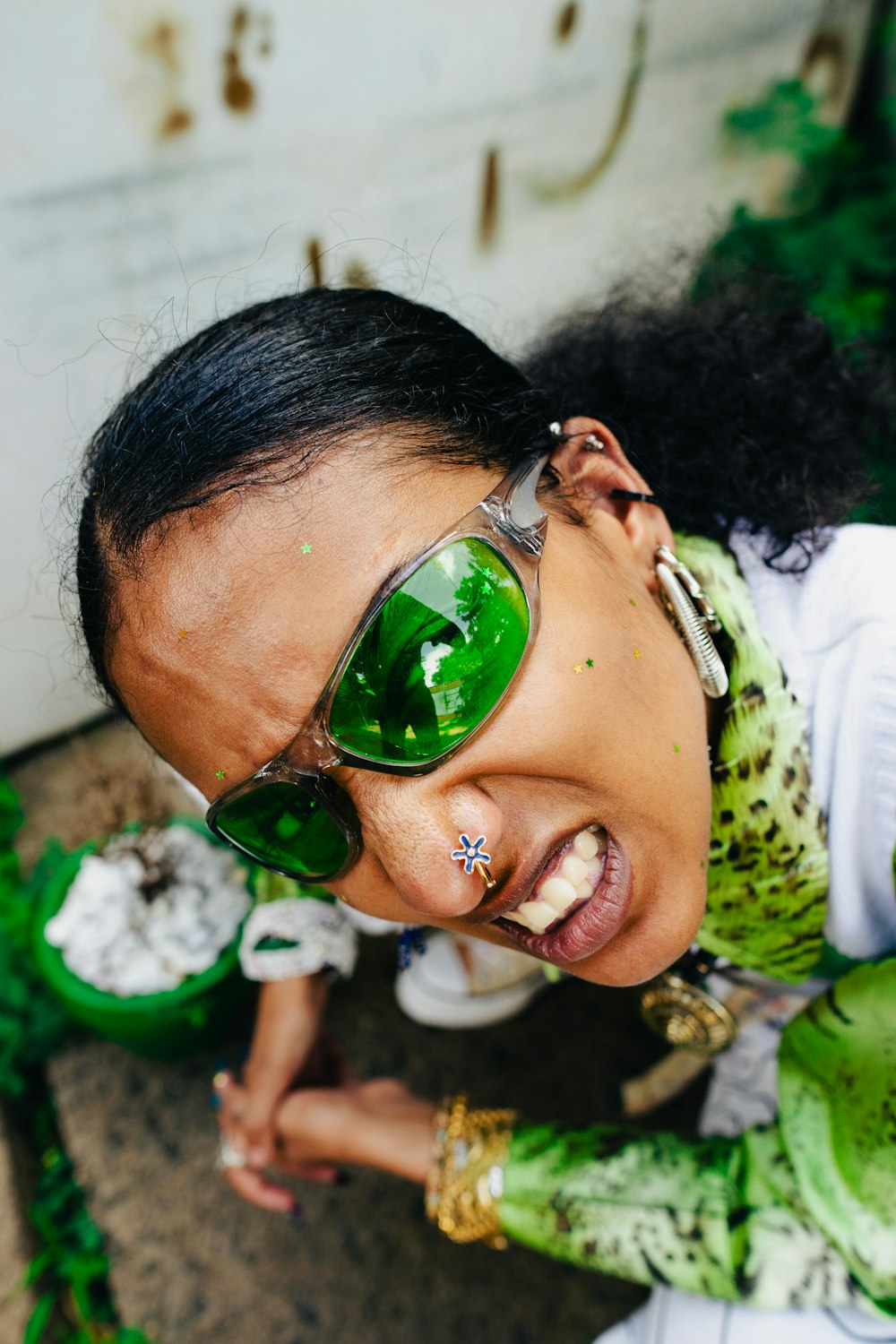 a woman wearing sunglasses and a green shirt