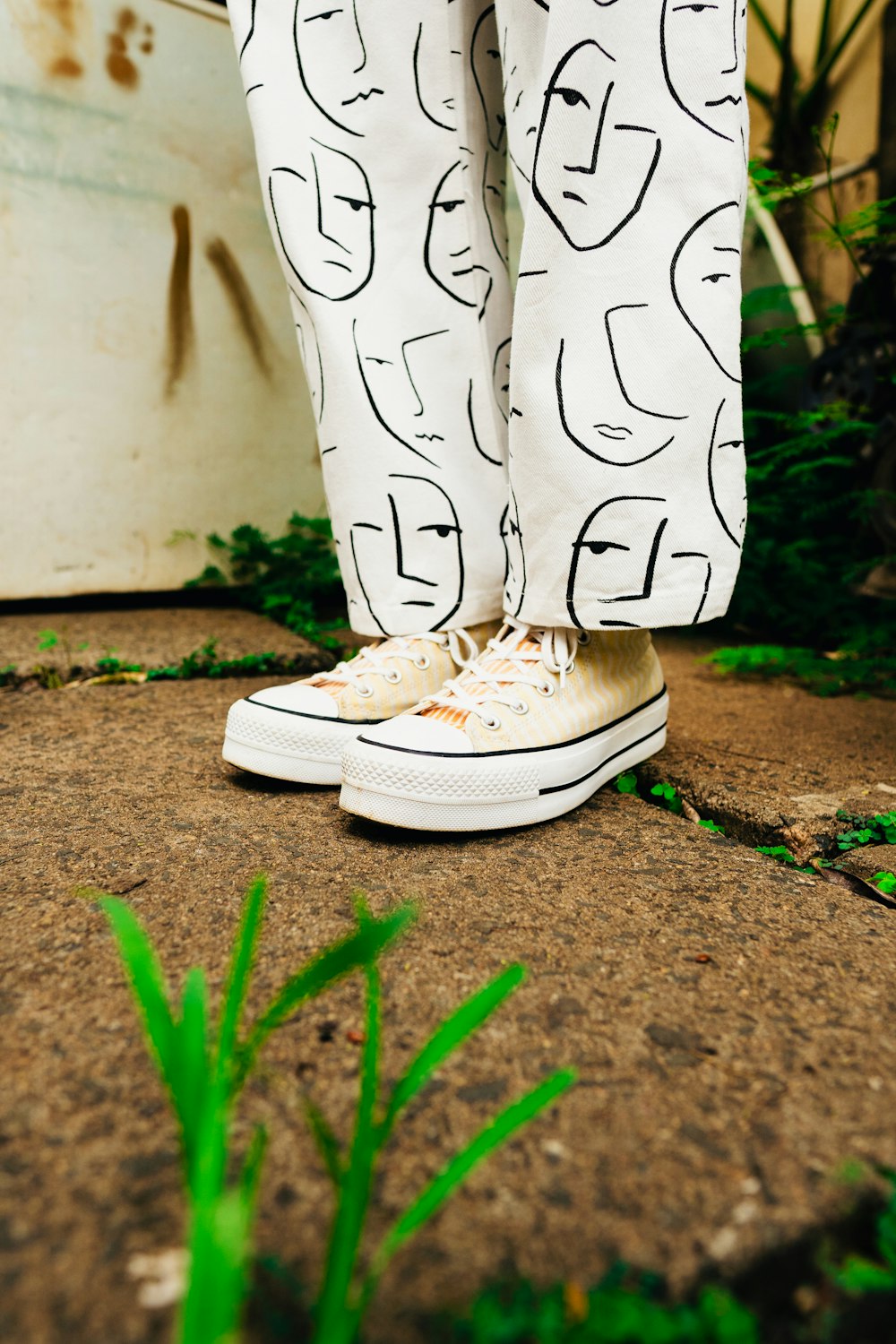 a person standing on the ground wearing white sneakers