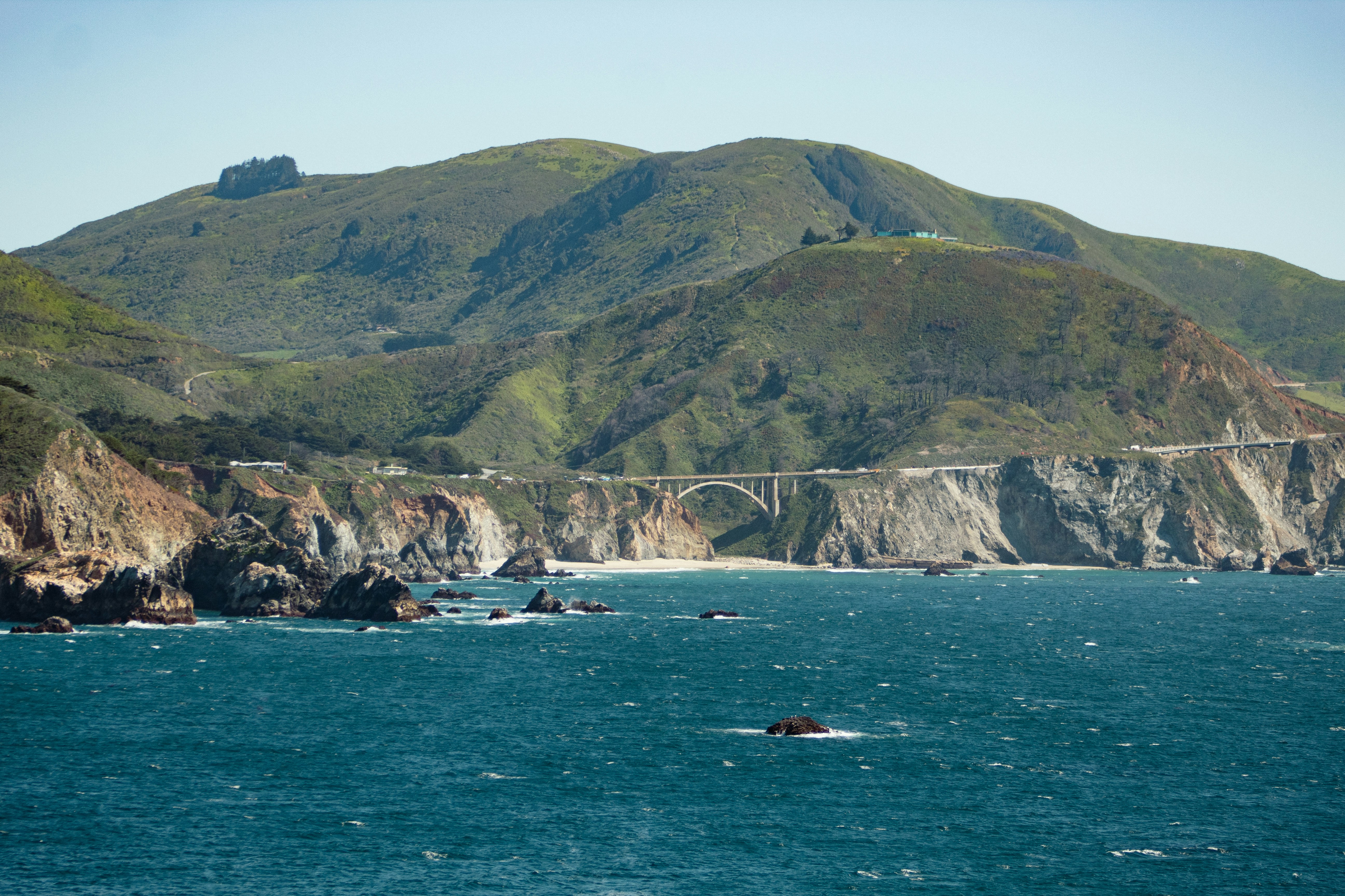a bridge over a body of water with mountains in the background