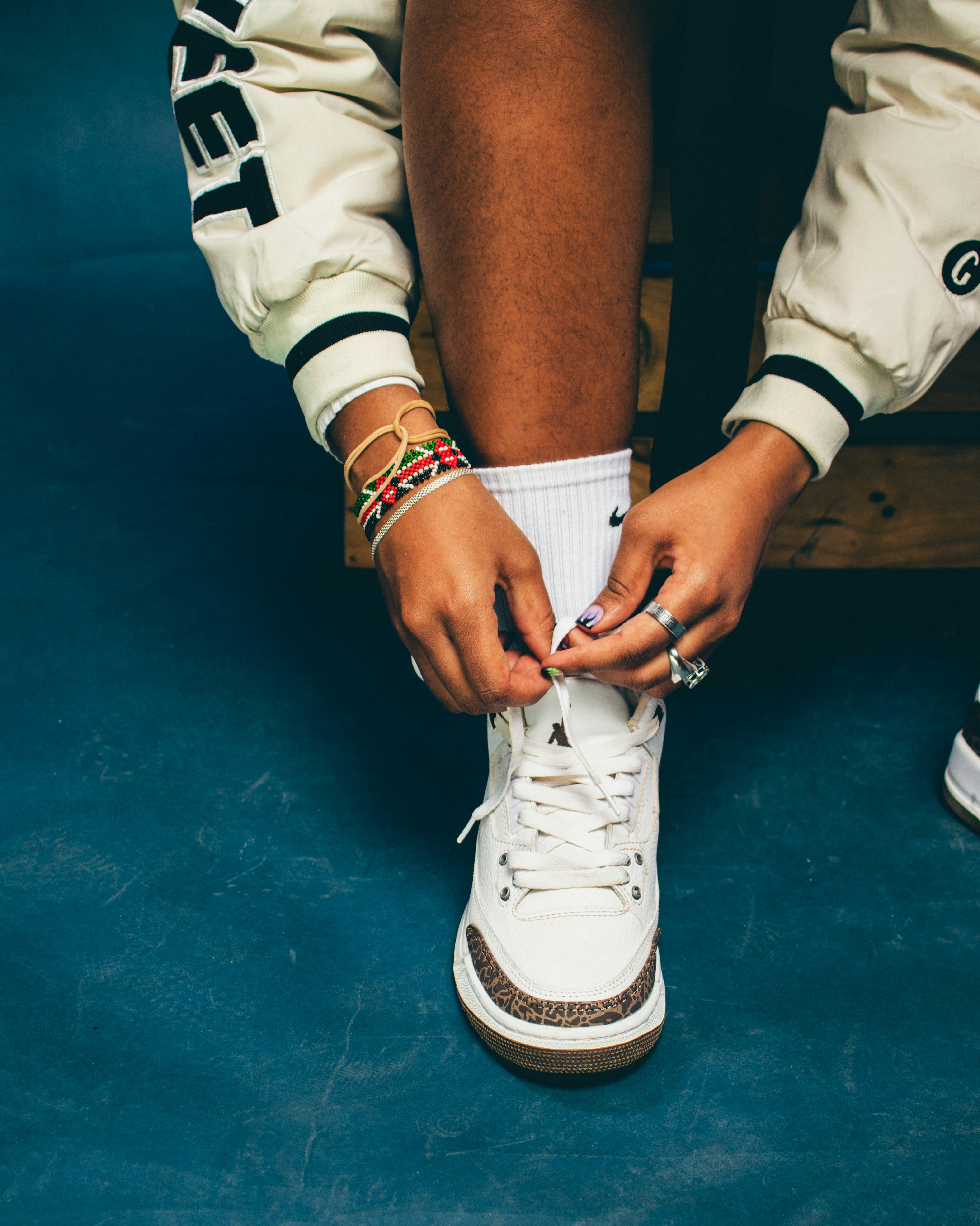 une personne nouant une paire de baskets blanches