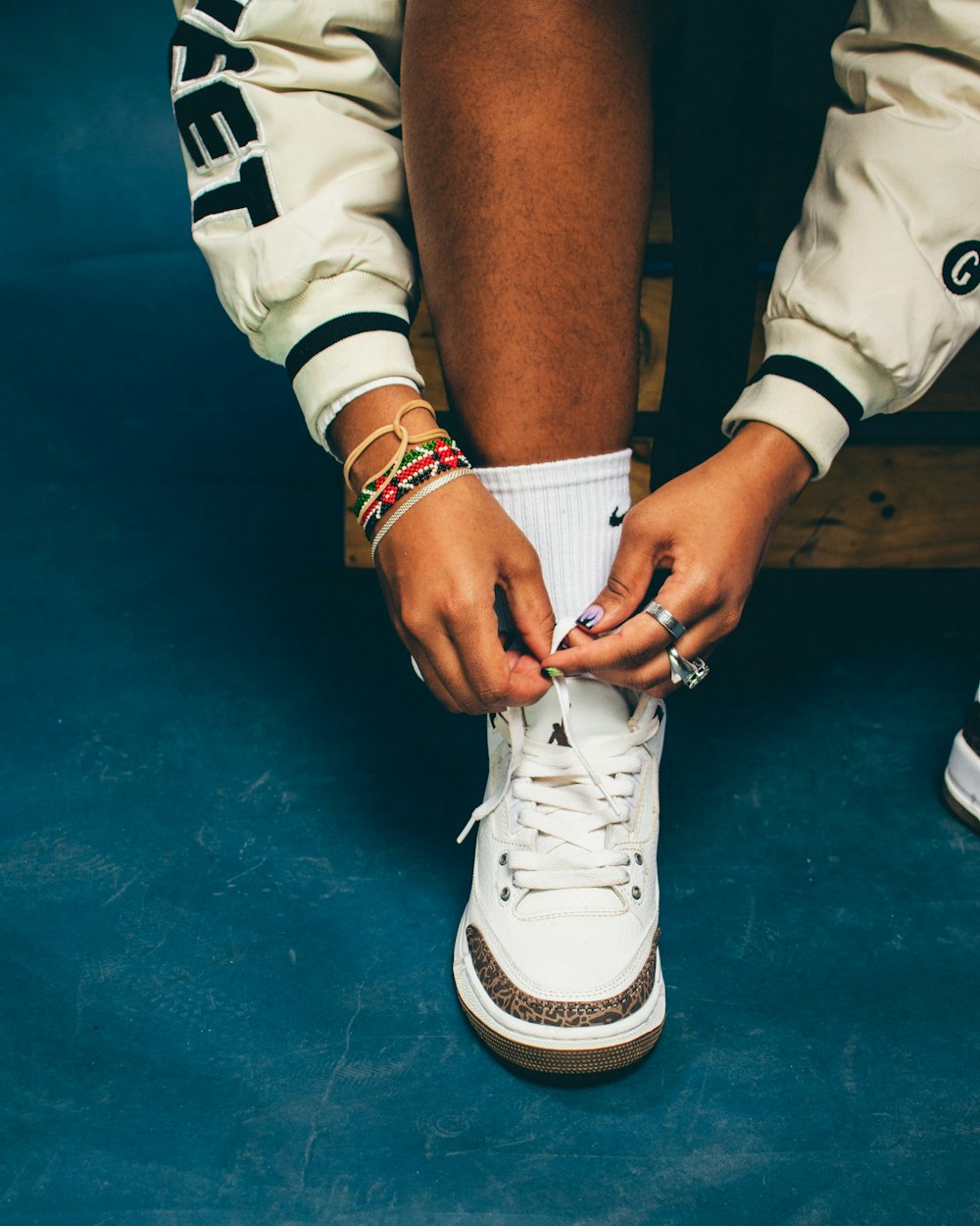 a person tying a pair of white sneakers