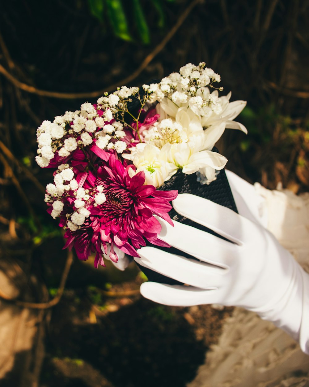a white glove holding a bouquet of flowers