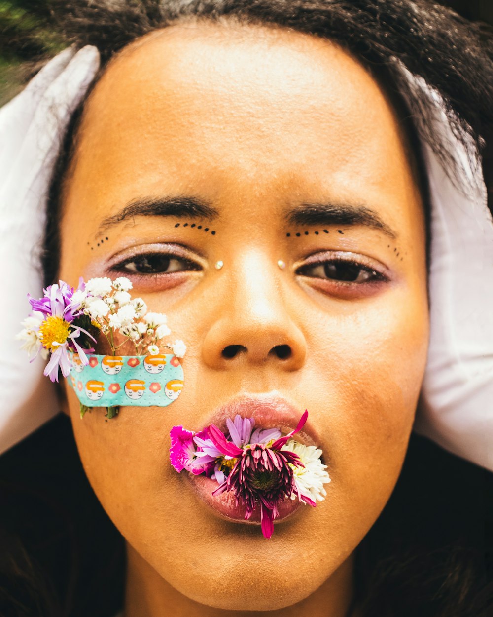 a woman with flowers sticking out of her nose