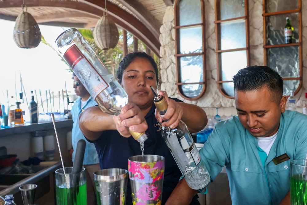 a woman pouring a drink into a glass