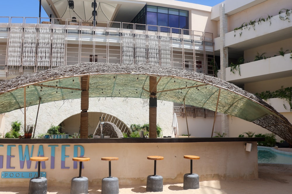 a group of stools sitting under an umbrella