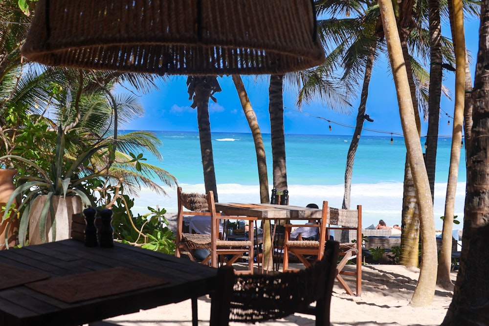 a table and chairs on a beach with palm trees