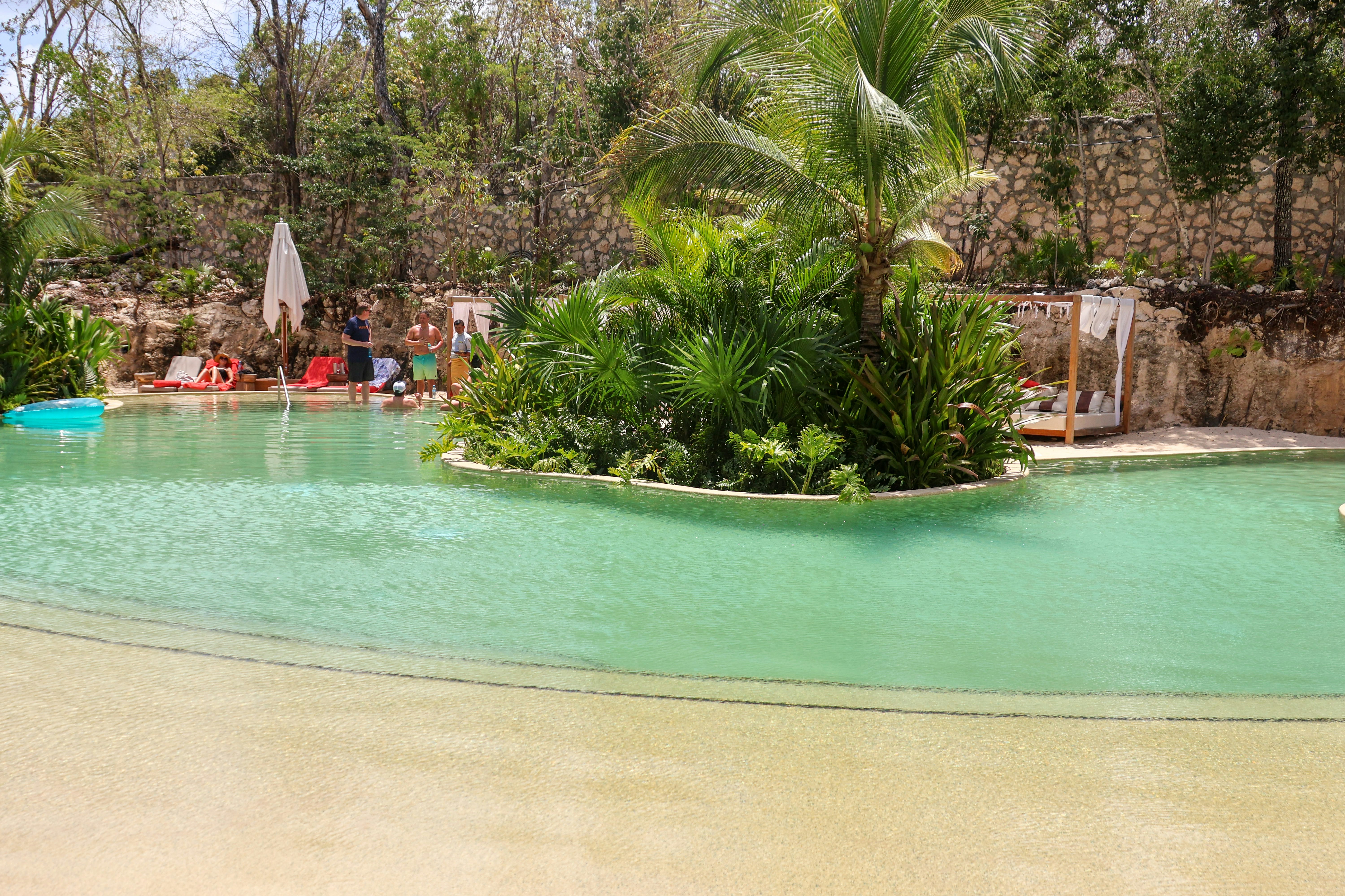 a group of people sitting around a swimming pool, 