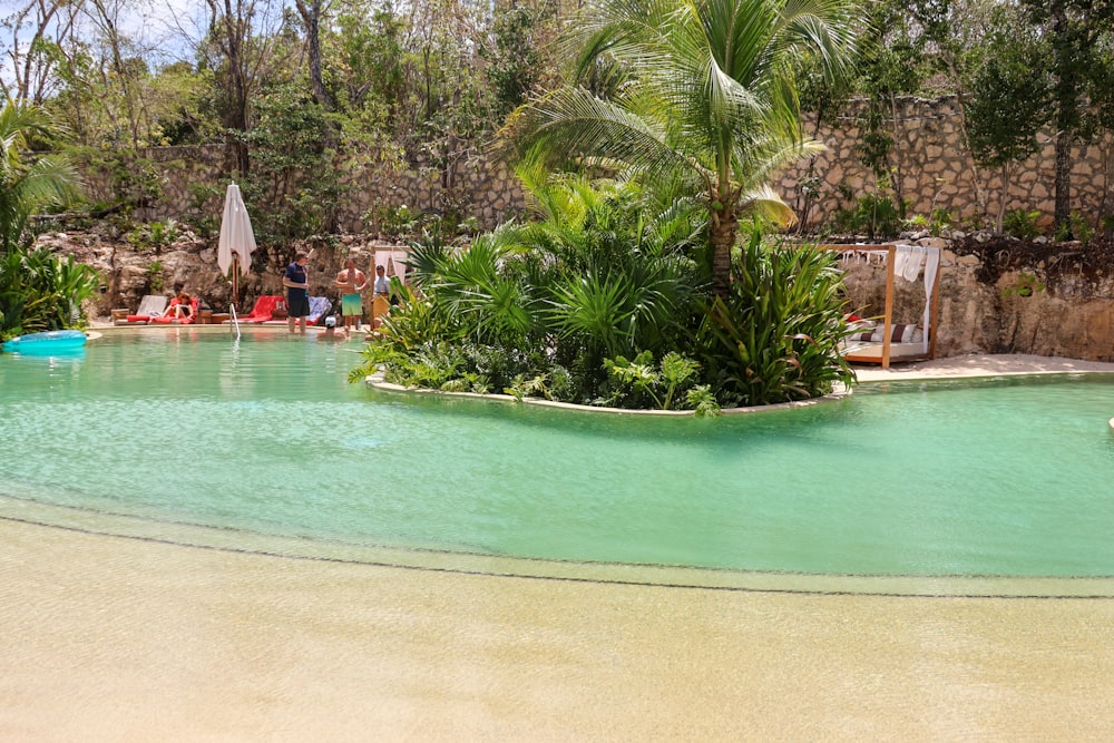 a group of people sitting around a swimming pool