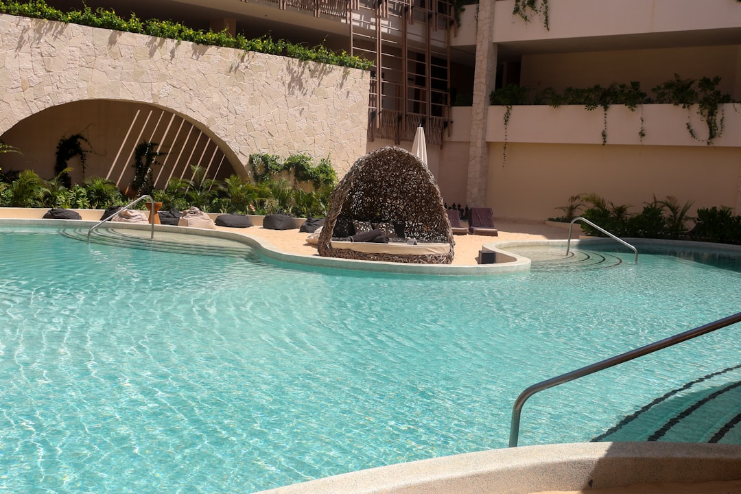 a swimming pool with a fountain in the middle of it,
