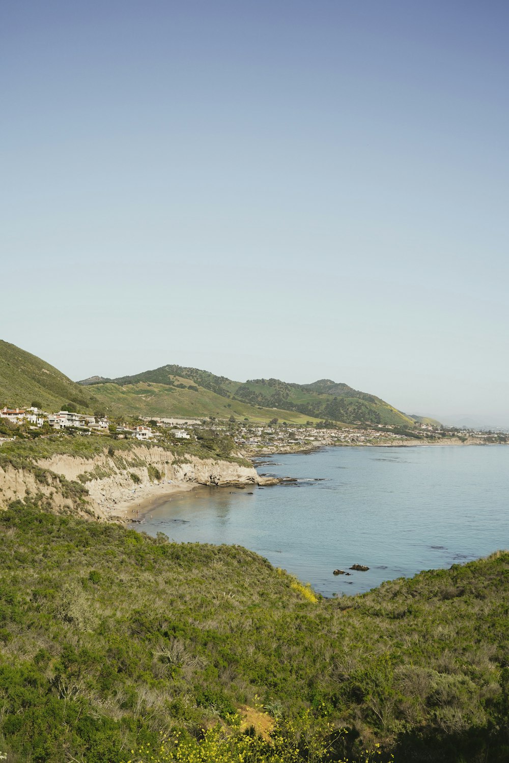 a body of water surrounded by lush green hills