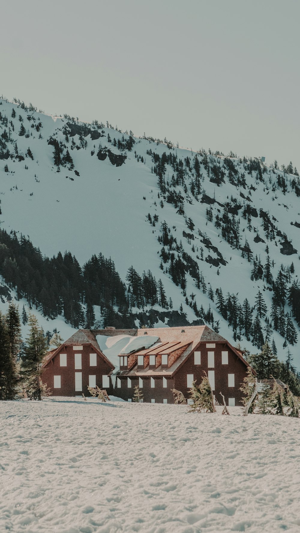 a snow covered mountain with a building in the foreground