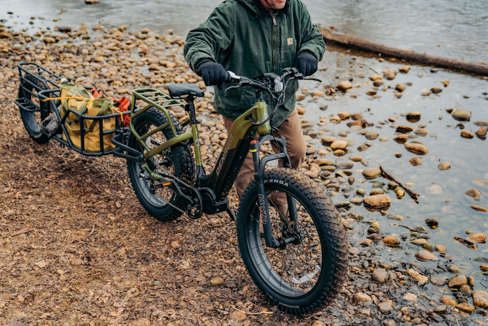 a man riding a bike next to a body of water