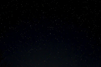 a night sky with stars and trees in the foreground
