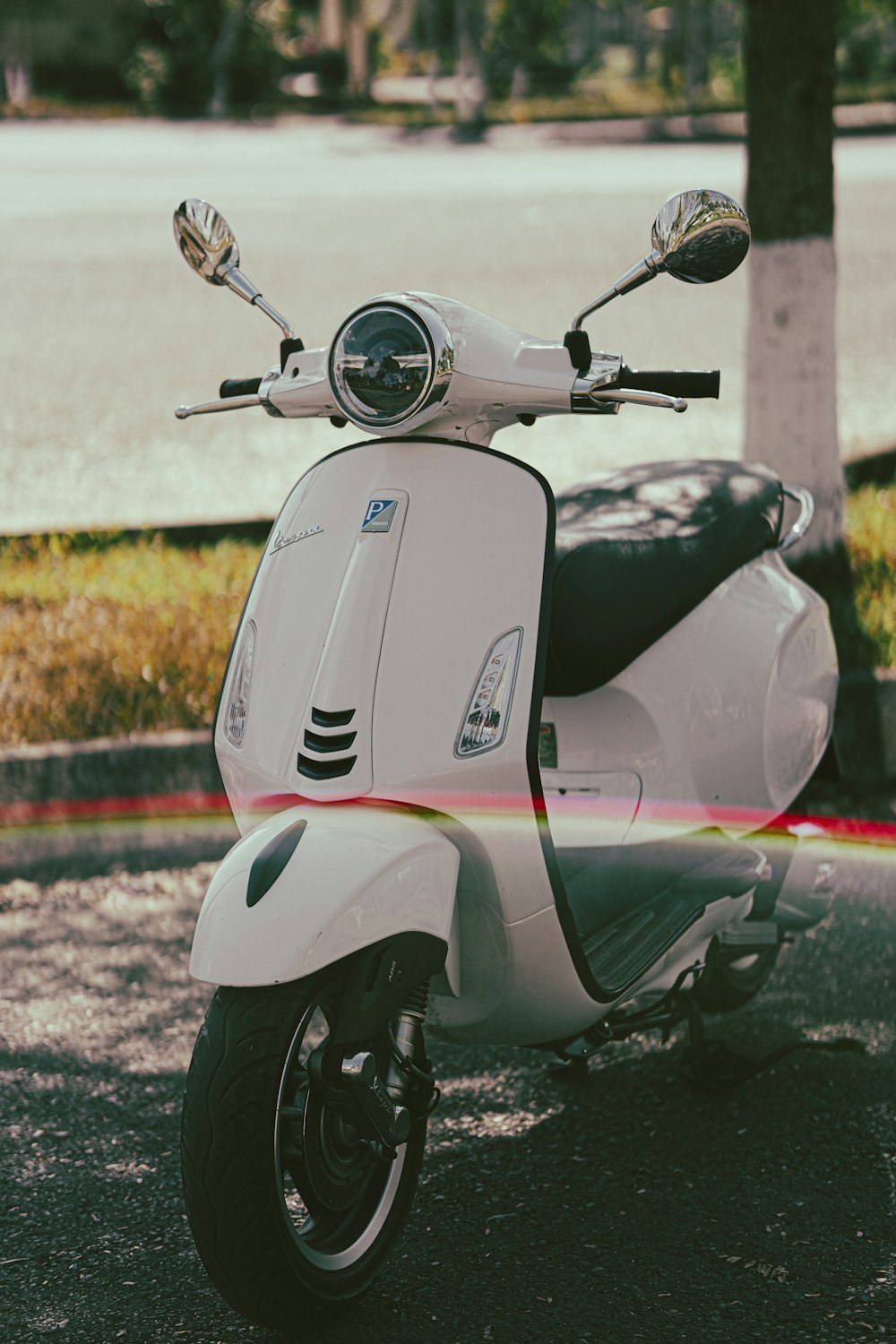 a white scooter parked on the side of the road