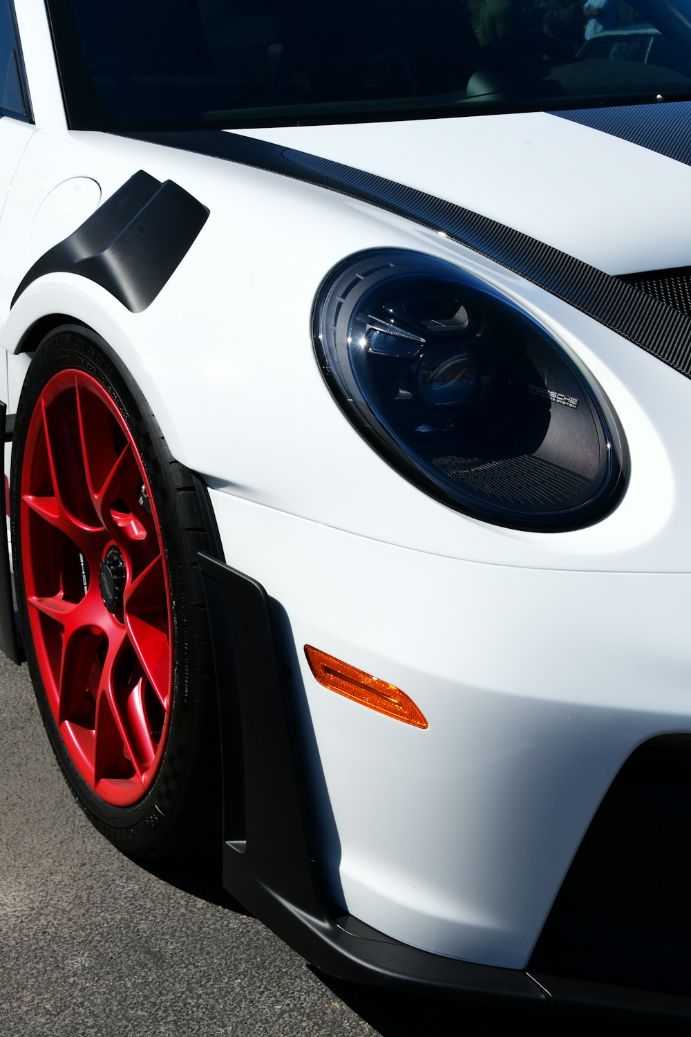 a close up of a white sports car with red rims