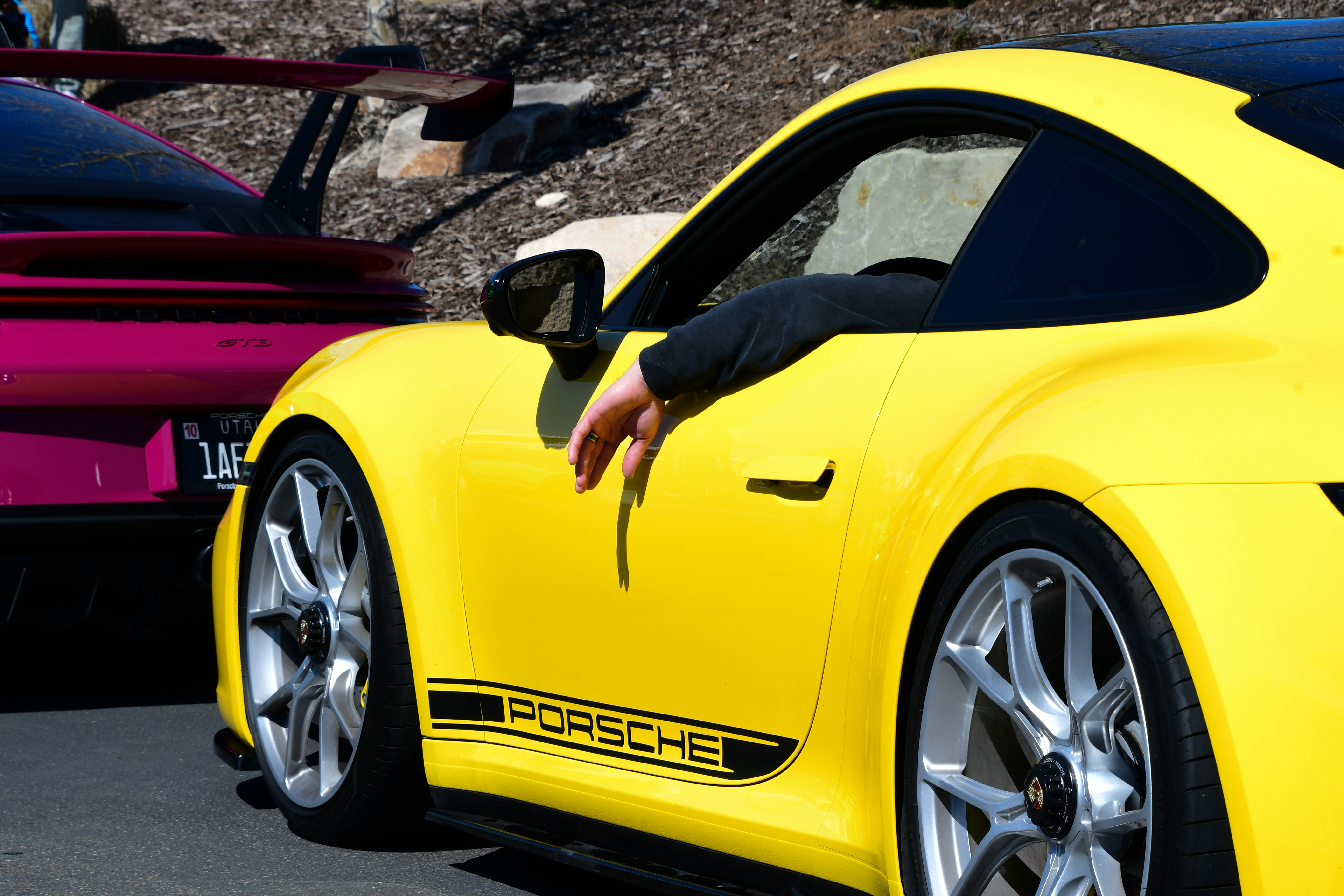 a person leaning out of a yellow sports car