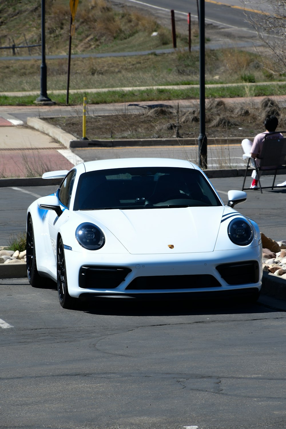 a white sports car parked in a parking lot