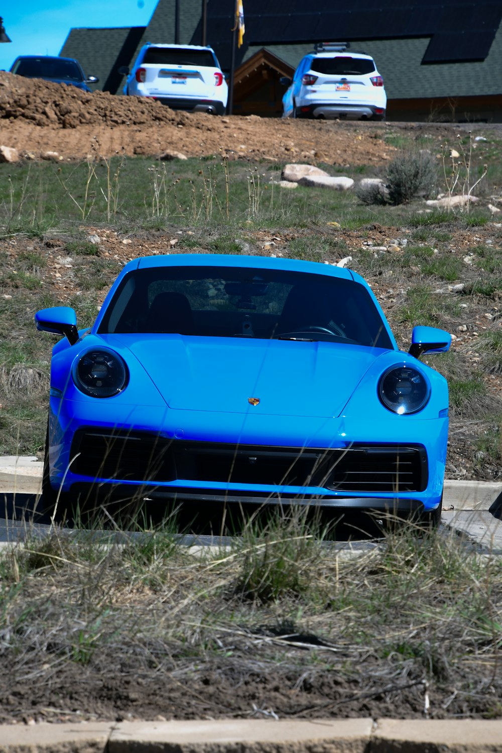 a blue sports car parked on the side of a road