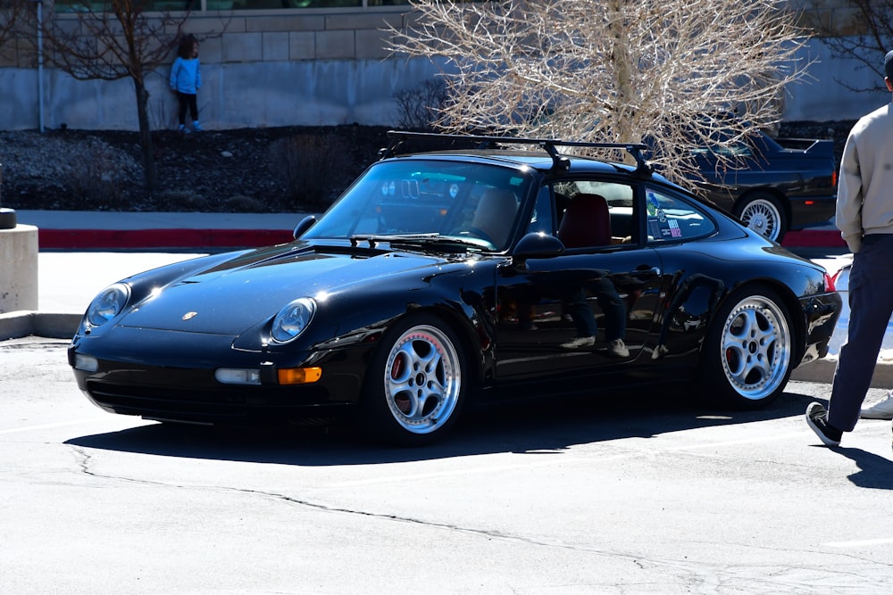 a black sports car parked in a parking lot