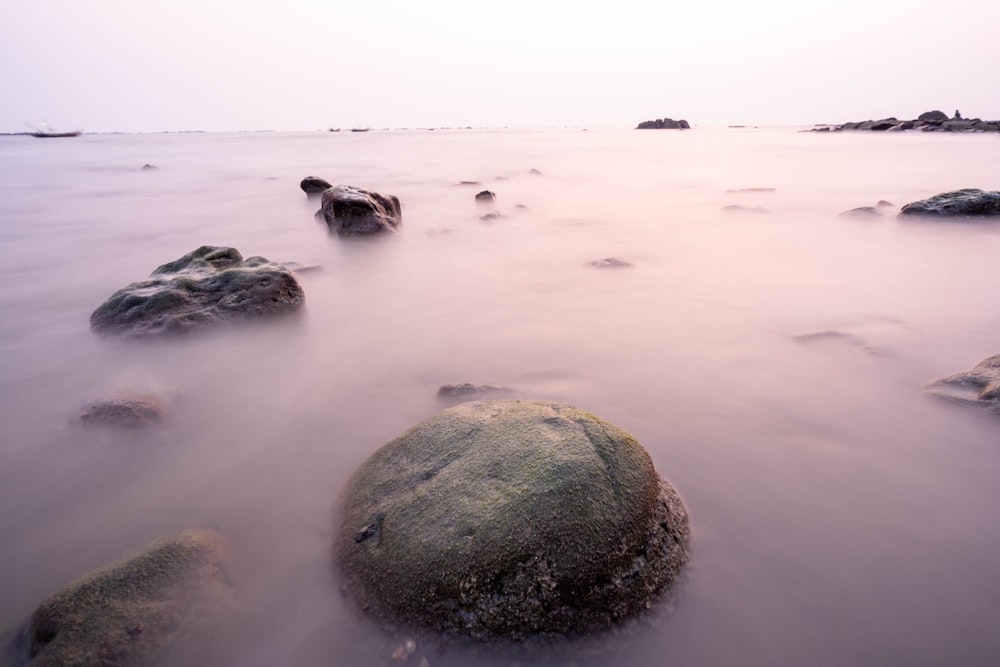 a long exposure photo of rocks in the water