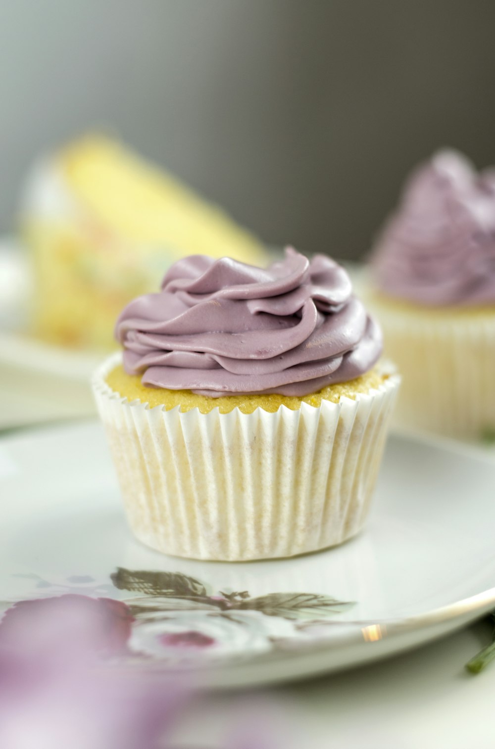 two cupcakes with purple frosting on a plate