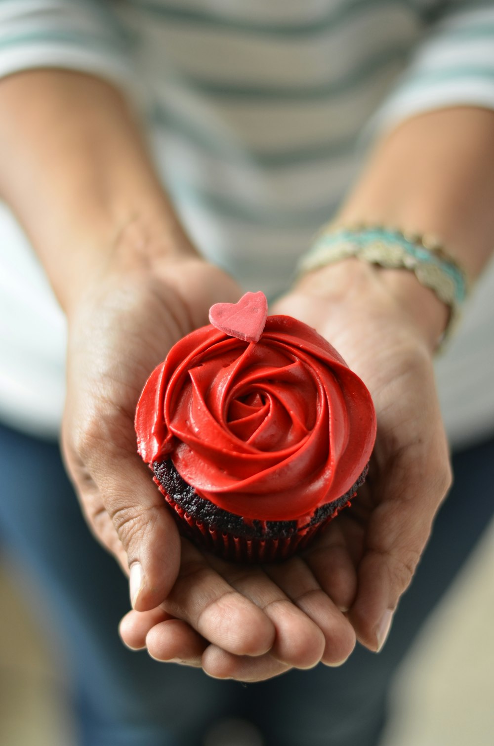 a person holding a cupcake in their hands