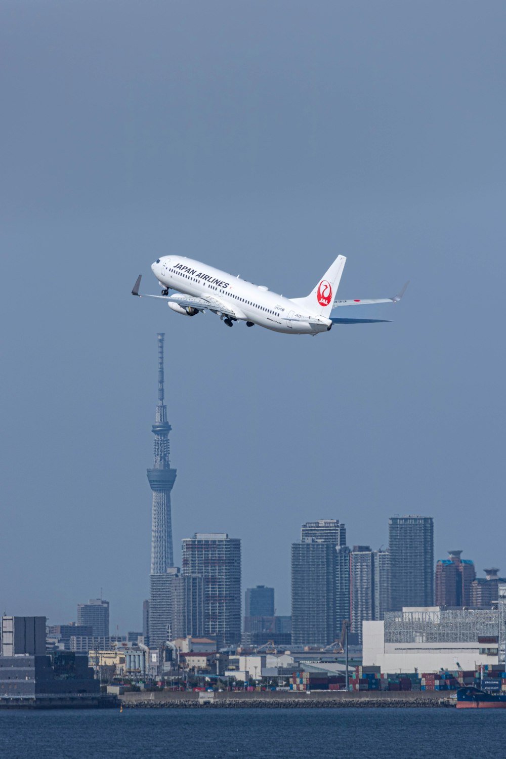 a large passenger jet flying over a city