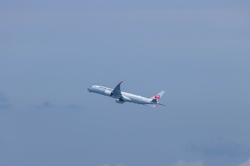 a large jetliner flying through a blue sky