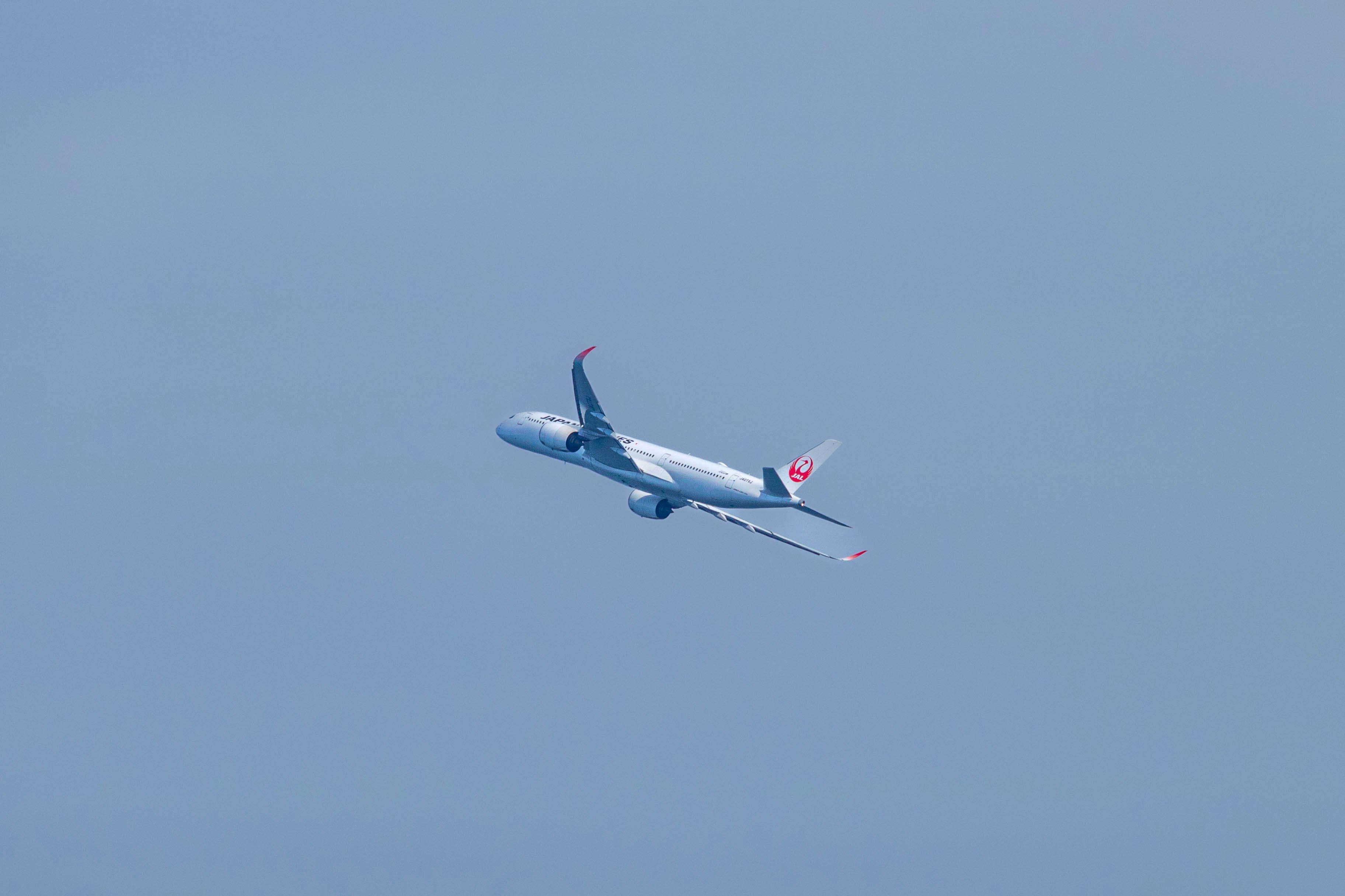 a large jetliner flying through a blue sky, 