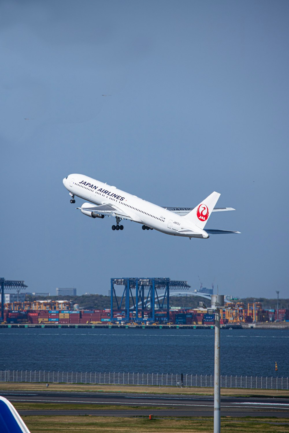 a large jetliner flying over a body of water