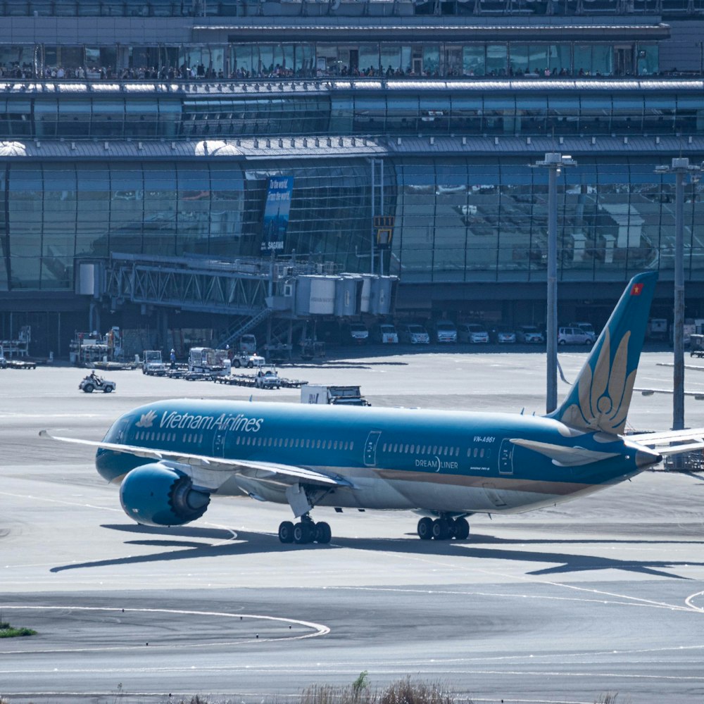 a blue and white airplane is on the runway